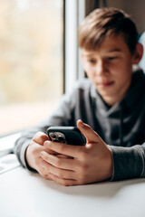Fototapeta premium Teen traveler using smartphone on train, modern digital lifestyle concept.