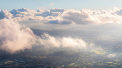 Obraz premium Frozen patchwork of rural landscape under clouds, seen from airplane window, showcasing muted winter tones and airy atmosphere with copy space