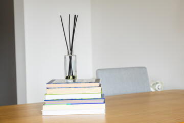 Reed diffuser on books. Knowledge, relaxation, and harmony of mind in home interior. Copy space