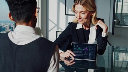 female advisor unspecified showing tablet graphs to client in glass office with city view, interactive portfolio review, risk analysis charts, professional manner, soft daylight and polished