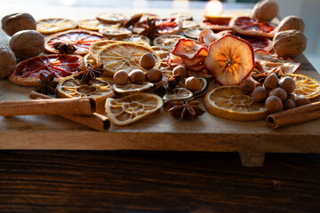 Dried citrus fruits and apple rings with nuts on rustic wood for Christmas. Preparations for christmas baking and hot drinks.