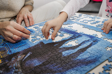 Parent and child putting puzzle pieces together. Symbol of family connection, focus, and creativity during mindful play