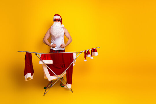 Santa in pajama at home doing laundry on a bright yellow background for a festive holiday stock photo