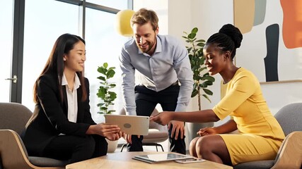 Diverse Business Team Collaborates in Modern Office Meeting Professionals Discuss Ideas Strategy and Solutions Using a Tablet in a Bright Lounge Setting