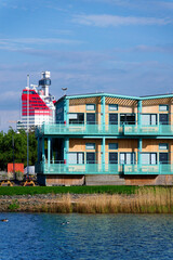 Fototapeta premium Sustainable cabins with natural materials on waterfront in Kvillepiren, Hisingen, sunny day, Gothenburg, Sweden