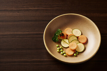 Healthy Sliced Carrots And Zucchini With Peas On Dark Wood Table