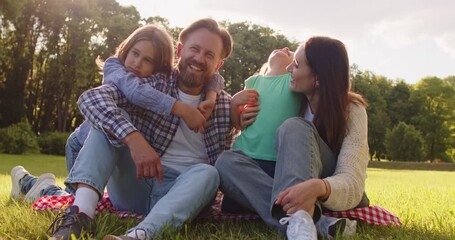 Summer day family fun together, playing in green park, children and two adults parents enjoying outdoor time, happily for recreational activity of happiness and connection, carefree weekend - Powered by Adobe