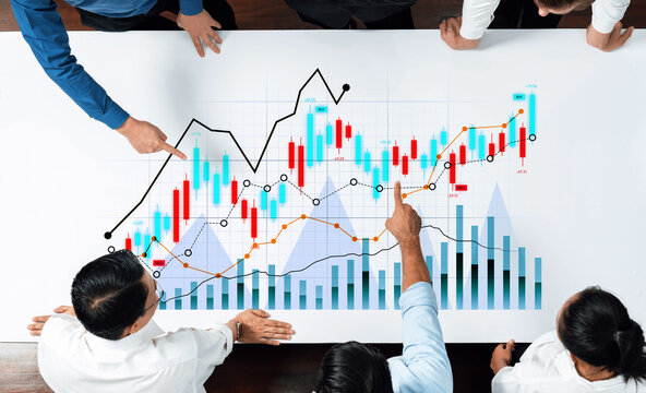 A group of business professionals engage in a collaborative meeting, analyzing financial data trends and charts to make informed strategic decisions for growth and market success. Scalp