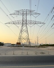 Electricity Transmission Tower Against a Hazy City Skyline at Dusk