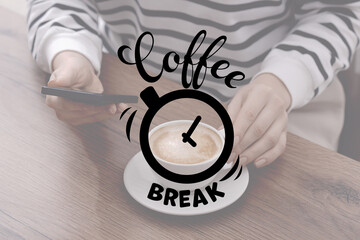 Coffee break time. Woman with cup of cappuccino using smartphone at table, closeup