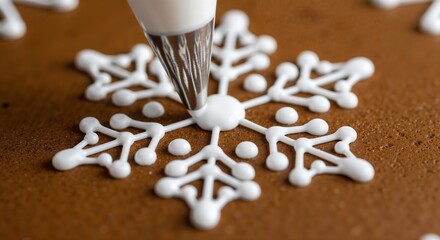 Close-up of white royal icing being piped in a detailed snowflake pattern onto a brown gingerbread cookie.