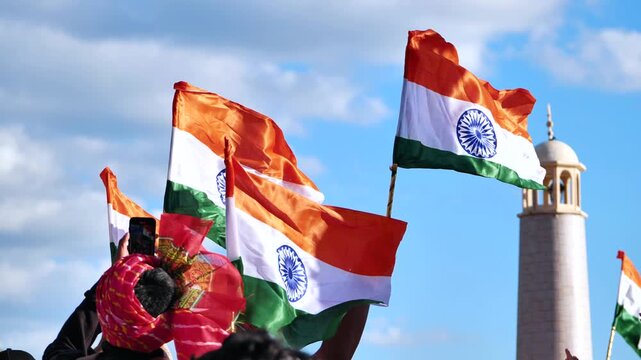 People celebrating national event, proudly waving Indian flags outdoors
