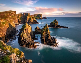 Rugged cliffs meet calm ocean waters at sunset with dramatic rock formations.