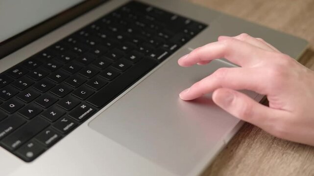 Close-up of Hand Using Laptop Trackpad for Digital Work