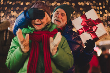 funny festive moment with surprise gift two elderly people laughing in a crowded outdoor holiday market scene