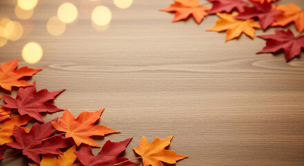 Obraz premium Autumnal maple leaves, colored red and orange, decorate a wooden surface. Bokeh lights add warmth, symbolizing seasonal transition and festive mood