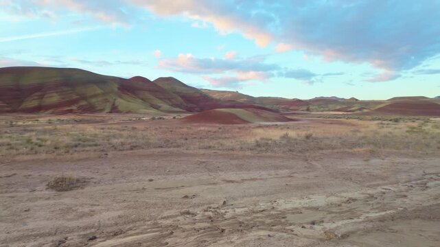 Vivid panoramic view of Painted Hills' vibrant red, gold, black layers from an elevated viewpoint at John Day Fossil Beds National Monument at sunrise