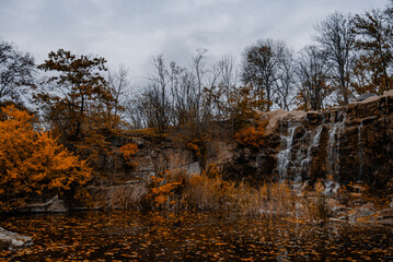 Seasonal leaf fall around cascading water and rugged canyon rocks