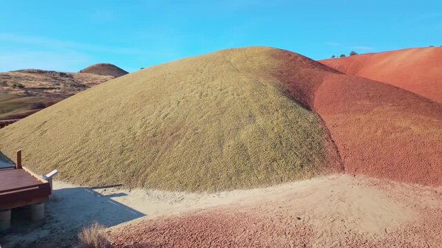 A scenic view of the short hiking trail winding through the small, colorful mounds of the Painted Cove area at John Day Fossil Beds National Monument at sunrise