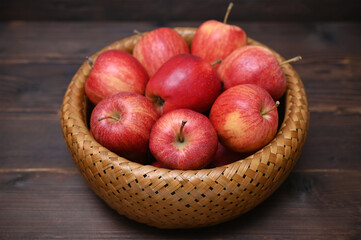 basket with red apples on a wooden background close-up