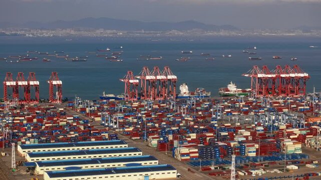 Unloading large cargo containers seaport. Loading freight sea port. Top aerial drone view. Lot big boxes rows, ship delivery ocean harbor. Industrial Shipping day. Goods export import. Marine dock.