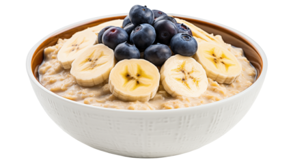 A bowl of oatmeal topped with sliced bananas and blueberries is on a white background isolated