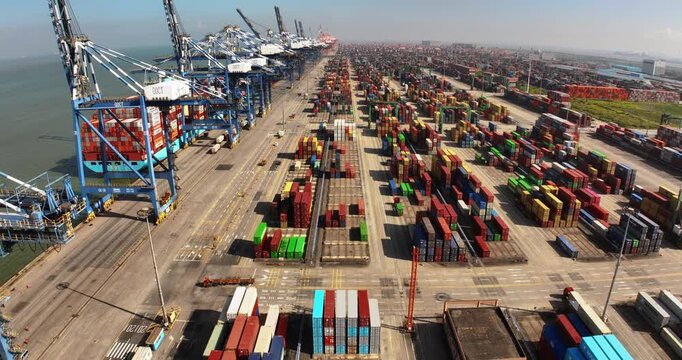 Unloading large cargo containers seaport. Loading freight sea port. Top aerial drone view. Lot big boxes rows, ship delivery ocean harbor. Industrial Shipping day. Goods export import. Marine dock.