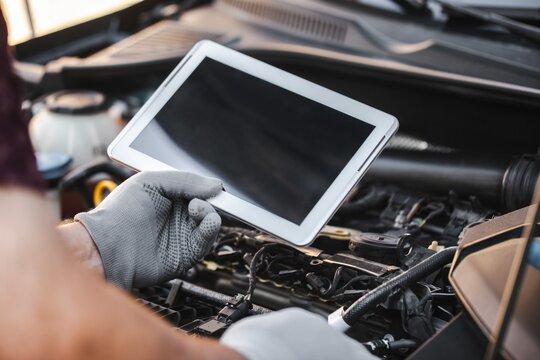 Mechanic uses a digital table to record error engine checks