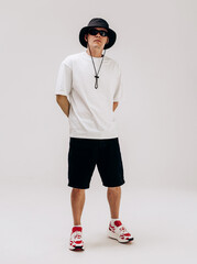 Young hip-hop dancer in street style summer outfit isolated on light background