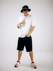 Young hip-hop dancer in street style summer outfit isolated on light background