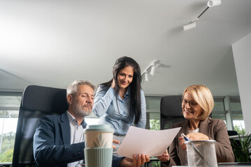 Casual meeting of smiling diverse business team analyzing financial data