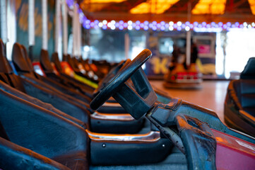 Colorful electric bumper cars parked on an amusement park arena.