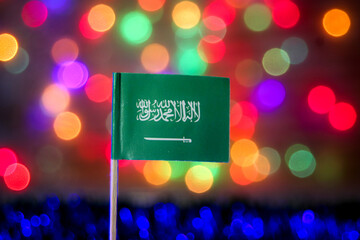 Saudi Arabia flag on colorful bokeh background, symbolizing unity, faith, and progress under Vision...