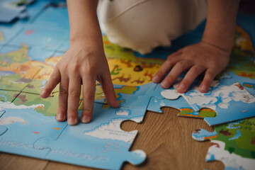 A child sits on the floor, assembling a colorful puzzle. Sunlight filters through the window,...