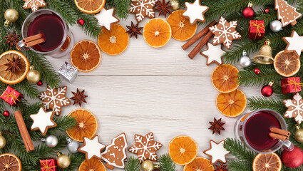 Christmas composition with mulled wine, dried oranges, gingerbread cookies, fir branches and festive decorations on wooden background.