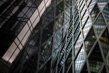 Glass facade reflection of a modern corporate building illustrating architectural geometry, design structure and clarity within a sophisticated urban skyline