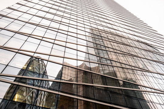 Modern architecture with glass facade reflection of corporate buildings, revealing geometric design structure and refined contemporary urban details