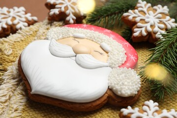 Tasty gingerbread cookies and fir tree branches on brown background, closeup. Christmas treat