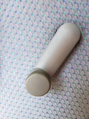 Close-up of manual car window crank handle on patterned grey-blue upholstery inside 1990s sedan, symbolizing retro automotive engineering and nostalgic details from pre-digital era