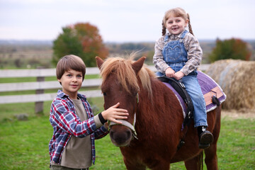 Equine assisted therapy. Cute children with beautiful pony outdoors. Lovely domesticated pet