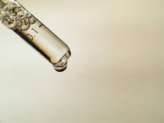 Close-up image of a clear glass pipette, partially filled with liquid. 