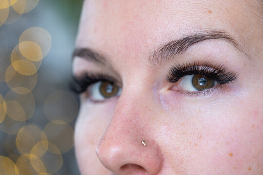 A woman has long extended eyelashes in a close-up with rhinestones. Preparing the image for the holiday