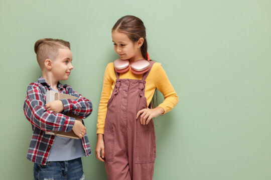 Cute little kids with books and headphones on pale green background, space for text - Powered by Adobe