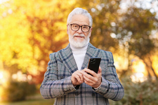 Handsome senior man with phone at park