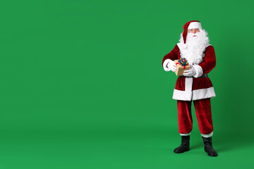 Santa Claus with Christmas gift on green background