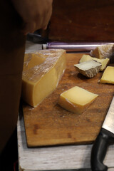 cuñas de queso italiano sobre una tabla rustica de madera