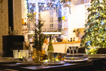 Festive interior of house is decorated for Christmas and New Year in loft style with black stove, fireplace, Christmas tree. Warm studio room with set table, burning wood, cozy and heating of home