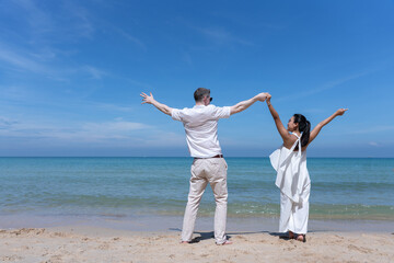 Happy couple jumping together on a tropical beach under a bright blue sky, symbolizing freedom, joy, and love. Perfect for travel, vacation, honeymoon, lifestyle, and summer inspiration concepts.