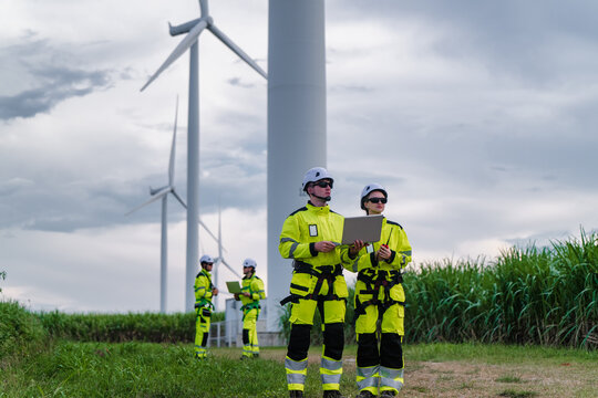 Engineers Discussion Blueprint Wide View Wind Farm Project. Future Grid Development Planning Huge Wind Turbine Site. Clean Energy Project Team Discussion Massive Scale Infrastructure