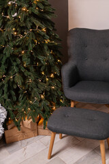 home christmas decor. living room interior for new years celebration. festive wreath, christmas tree. white sheets. couch, blanket, garland, presents. grey. minimalistic